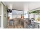 Covered outdoor kitchen boasts a built-in grill, mini-fridge, and stone accents at 11913 Butler Woods Cir, Riverview, FL 33579