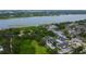 Scenic aerial view of apartments near a lake, surrounded by lush greenery and ample parking at 12261 Sailwinds Dr # 203, Largo, FL 33773