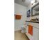 Well-lit bathroom featuring a modern vanity with marble countertop, toilet, and tropical artwork at 12261 Sailwinds Dr # 203, Largo, FL 33773