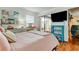 Bedroom with sliding glass door to the balcony, desk, and tv on the wall at 12261 Sailwinds Dr # 203, Largo, FL 33773