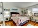 Bright bedroom featuring surf-themed decor, hardwood floors, and a comfortable bed at 12261 Sailwinds Dr # 203, Largo, FL 33773
