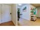 Inviting hallway with neutral tile, a coastal-themed artwork, and a view toward the sliding glass door at 12261 Sailwinds Dr # 203, Largo, FL 33773