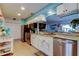 Renovated kitchen with stainless steel appliances, white cabinets, and a view into the dining room at 12261 Sailwinds Dr # 203, Largo, FL 33773