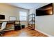 Well-lit office space with modern desk, shelves, and flat screen tv at 12261 Sailwinds Dr # 203, Largo, FL 33773