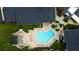 Aerial view showcasing a uniquely shaped pool, lounge area, and lush landscaping within a community at 12261 Sailwinds Dr # 203, Largo, FL 33773