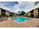 Community pool area with brick paved deck, lounge chairs, and meticulously maintained landscaping at 12261 Sailwinds Dr # 203, Largo, FL 33773