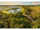 Scenic aerial view of a community, showcasing a pond with wooden bridge and lush landscaping at 12586 Somatic Ct, Venice, FL 34293