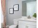 This well-lit bathroom includes a vanity with quartz countertop, a toilet, a framed art and a tub with shower at 12586 Somatic Ct, Venice, FL 34293