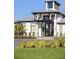 Close-up view of a modern entrance with a black metal roof, glass doors, and manicured landscaping at 12586 Somatic Ct, Venice, FL 34293