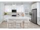 Bright kitchen featuring white cabinetry, stainless steel appliances, and a center island with seating at 12586 Somatic Ct, Venice, FL 34293