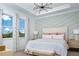 This serene main bedroom features an accent wall, a large bed, an abundance of natural light, and a modern light fixture at 12586 Somatic Ct, Venice, FL 34293
