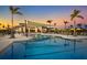 Stunning community pool with expansive deck, shade structures, and lush landscaping, perfect for leisure and socializing at 12586 Somatic Ct, Venice, FL 34293