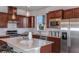 Modern kitchen with stainless steel appliances, island with seating, and dark wood cabinets at 13740 Rocky Pine Pl, Spring Hill, FL 34610