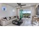 Cozy living room featuring a sectional sofa and access to a screened patio with a view at 13740 Rocky Pine Pl, Spring Hill, FL 34610