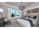 Serene primary bedroom with chandelier and view of lake through a large window at 13740 Rocky Pine Pl, Spring Hill, FL 34610