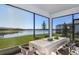 Covered patio with seating area, overlooking a beautiful lake view and lawn at 13740 Rocky Pine Pl, Spring Hill, FL 34610