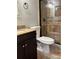 Bathroom features a dark vanity with a granite countertop, a mosaic mirror, and a tiled shower at 1400 Pine Glen Ln # D2, Tarpon Springs, FL 34688