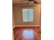 Bedroom features a window with blinds, hardwood floors, and neutral paint at 1400 Pine Glen Ln # D2, Tarpon Springs, FL 34688