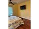 Bedroom features a ceiling fan, window with blinds, hardwood floors, and a TV on the wall at 1400 Pine Glen Ln # D2, Tarpon Springs, FL 34688
