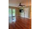 Bright living room with wood floors, a sliding glass door, and modern ceiling fan at 1400 Pine Glen Ln # D2, Tarpon Springs, FL 34688