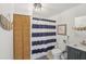 Clean bathroom with a vanity, toilet, and a shower with a blue and white striped curtain at 1438 Poinciana Dr, Clearwater, FL 33764