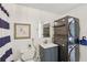 Bright bathroom featuring modern washer/dryer unit, decorative starfish art, and tasteful blue-and-white accents at 1438 Poinciana Dr, Clearwater, FL 33764