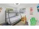 Bright bedroom featuring a bunk bed, two windows and fun decor at 1438 Poinciana Dr, Clearwater, FL 33764