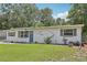 Charming single-story home featuring a well-maintained lawn and a blue front door at 1438 Poinciana Dr, Clearwater, FL 33764