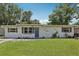 Charming single-story home featuring a well-maintained lawn and a blue front door at 1438 Poinciana Dr, Clearwater, FL 33764