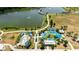 This aerial shows a splash park with waterslides, beach umbrellas and covered playground at 14509 Thornfield Ct, Tampa, FL 33624