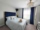 Bright bedroom featuring a blue velvet headboard, chandelier, and natural light at 14509 Thornfield Ct, Tampa, FL 33624