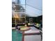Covered pool area featuring a jacuzzi, stylish seating, and lush greenery at 14509 Thornfield Ct, Tampa, FL 33624