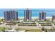 Aerial view of beachfront condos with pools, tennis courts, and ocean access at 1520 Gulf Blvd # 1502, Clearwater Beach, FL 33767