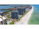 Stunning aerial view of beachfront condominiums, lush landscaping, and pristine sandy beach, offering a luxurious coastal lifestyle at 1520 Gulf Blvd # 1502, Clearwater Beach, FL 33767