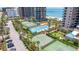 Aerial view of resort-style amenities, including pool, tennis courts, and lush landscaping at 1520 Gulf Blvd # 1502, Clearwater Beach, FL 33767