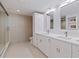 Bright bathroom featuring double vanity with white cabinets, tile flooring, and glass enclosed shower at 1520 Gulf Blvd # 1502, Clearwater Beach, FL 33767