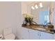 Clean and updated bathroom with granite countertop, white cabinetry, and decorative mirror at 1520 Gulf Blvd # 1502, Clearwater Beach, FL 33767