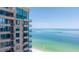 Condo building with balconies offering stunning views of the turquoise ocean and white sand beach on a sunny day at 1520 Gulf Blvd # 1502, Clearwater Beach, FL 33767