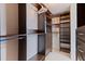 Spacious walk-in closet with custom dark wood shelving and ample storage space at 1520 Gulf Blvd # 1502, Clearwater Beach, FL 33767