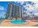 Luxury high-rise condo featuring a large pool and sundeck with tropical landscaping at 1520 Gulf Blvd # 1502, Clearwater Beach, FL 33767