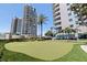 A lush putting green offers a recreational retreat with beautiful landscaping around high-rise buildings at 1520 Gulf Blvd # 1502, Clearwater Beach, FL 33767