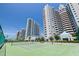 Well-maintained tennis court offering a scenic view of modern buildings and lush landscaping at 1520 Gulf Blvd # 1502, Clearwater Beach, FL 33767