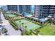 Aerial view of tennis courts surrounded by tropical landscaping and modern high-rise buildings at 1520 Gulf Blvd # 1502, Clearwater Beach, FL 33767