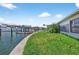 Landscaped backyard with green grass and canal access and dock at 17444 2Nd E St, Redington Shores, FL 33708