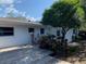 Outdoor deck with lush landscaping, a beautiful tree, and a white house facade at 1875 Harmony Dr, Clearwater, FL 33756