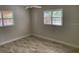 Cozy bedroom with neutral walls, tile flooring, a ceiling fan, and plantation shutters on windows at 1875 Harmony Dr, Clearwater, FL 33756