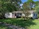A well-kept single-story home boasting a lush green lawn and established landscaping in a serene neighborhood at 1875 Harmony Dr, Clearwater, FL 33756