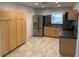 Kitchen boasts stainless steel appliances, tile backsplash, lots of wooden cabinet storage and tile floors at 1875 Harmony Dr, Clearwater, FL 33756