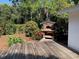 Exterior view of the pizza oven, deck and beautiful landscaping in a serene backyard setting at 1875 Harmony Dr, Clearwater, FL 33756