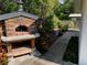 Exterior stone pizza oven sitting next to the wooden deck and lush landscaped backyard at 1875 Harmony Dr, Clearwater, FL 33756